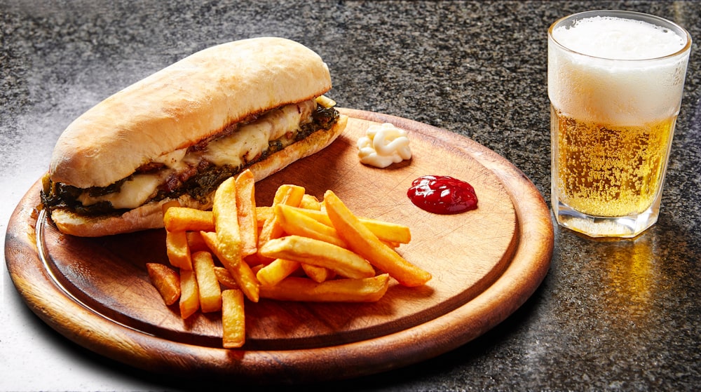 burger and fries on brown wooden round plate