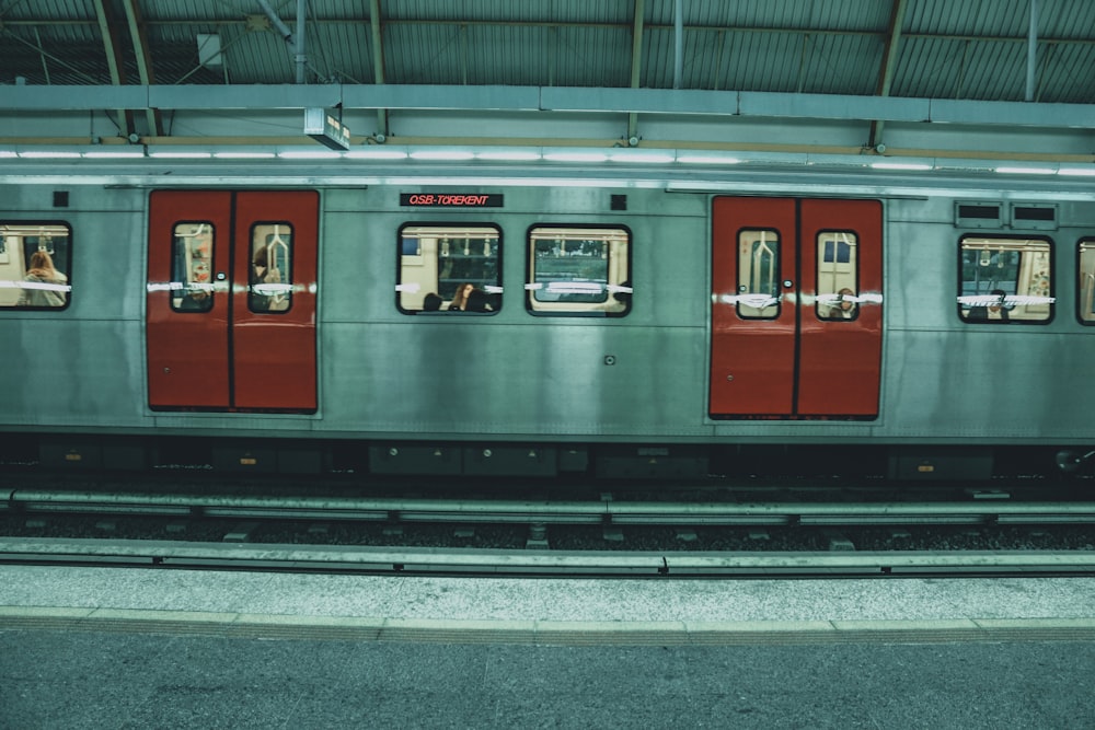 red and gray train in train station