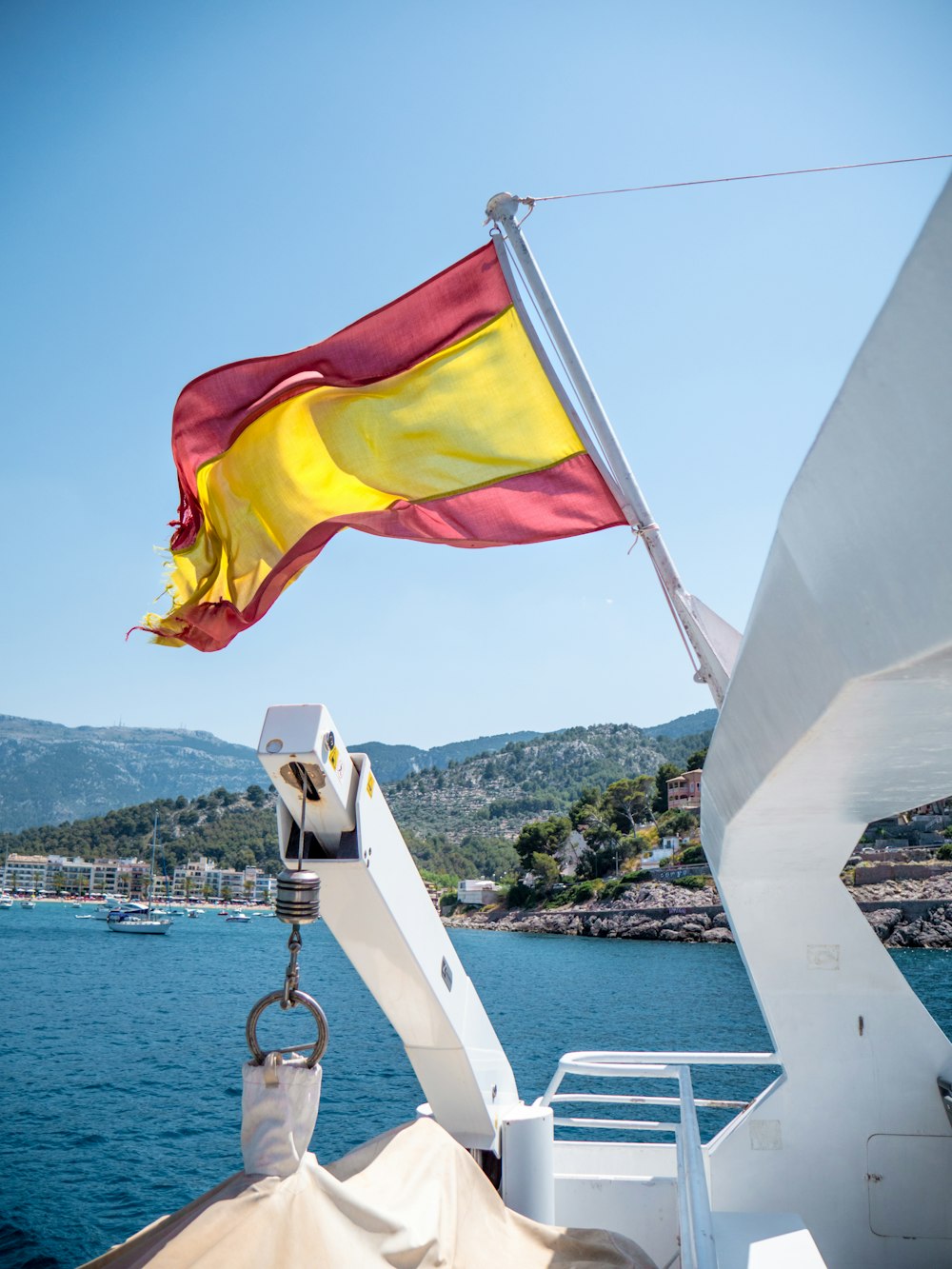 white and yellow flag on white boat during daytime