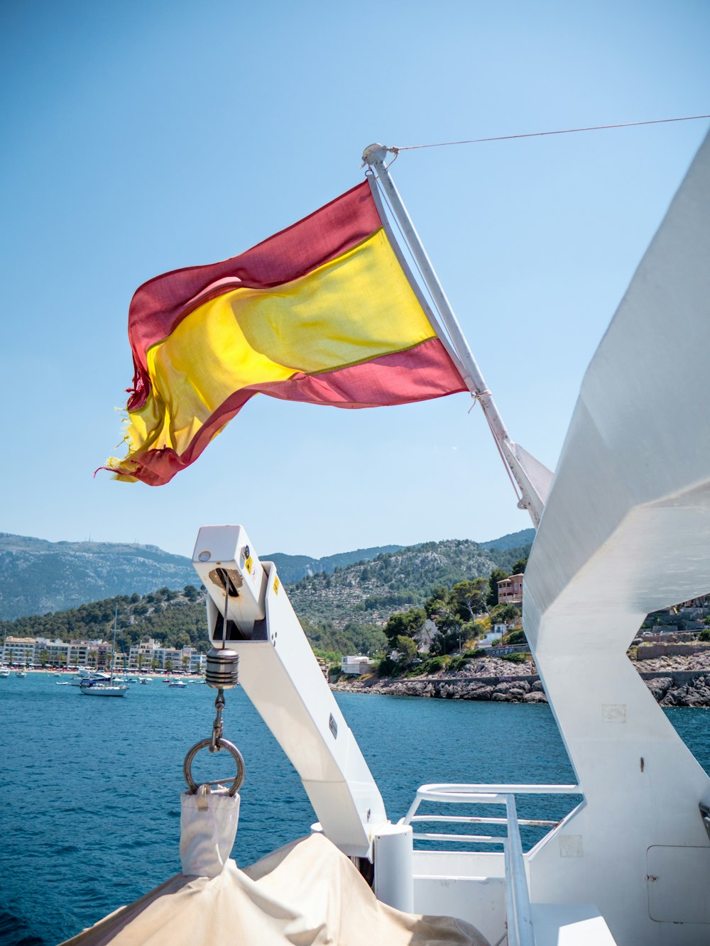 Bandera blanca y amarilla en barco blanco durante el día