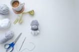 Artistic flat lay of colorful yarns and crochet hooks in shadowy light.