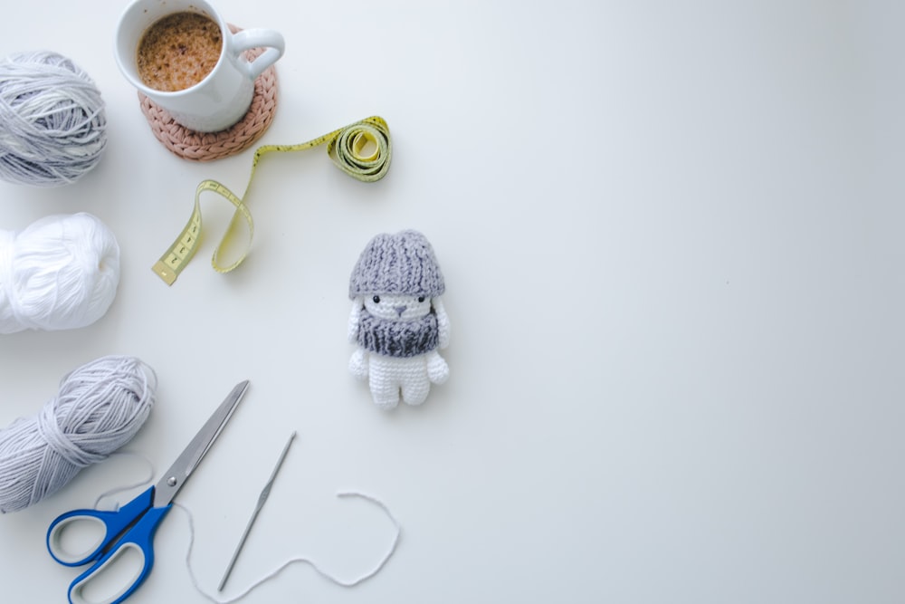 white and black knit cap on white ceramic mug