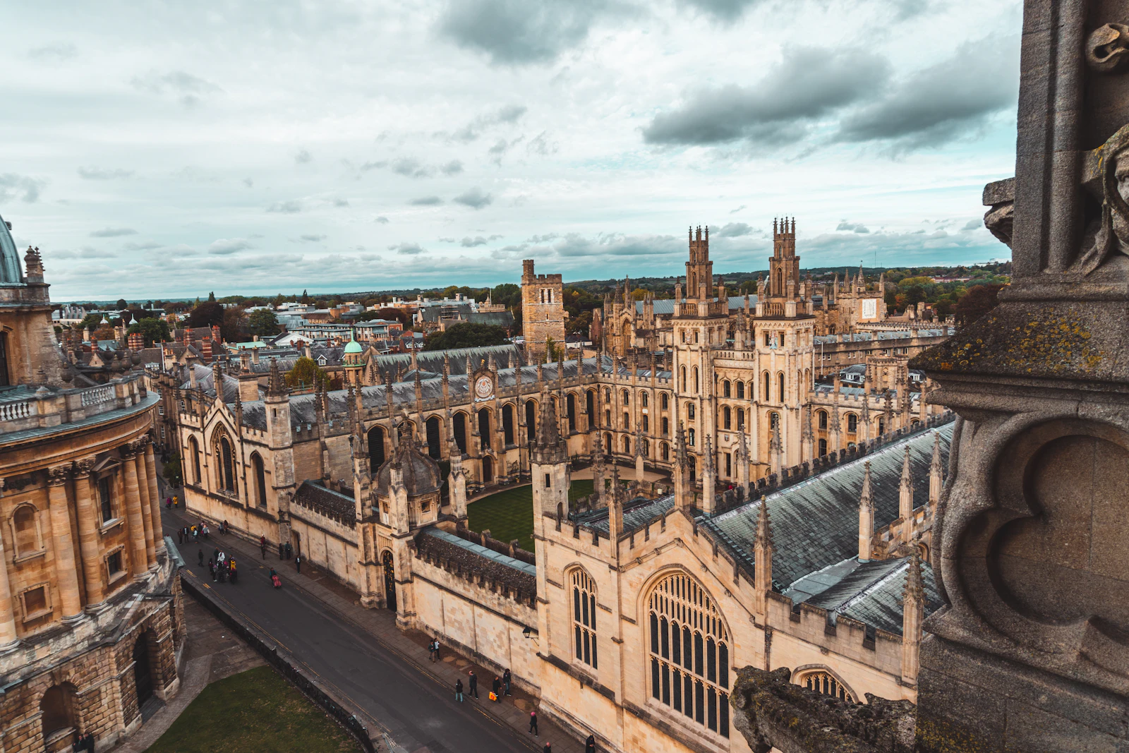 Historic university buildings in central Oxford under a cloudy sky