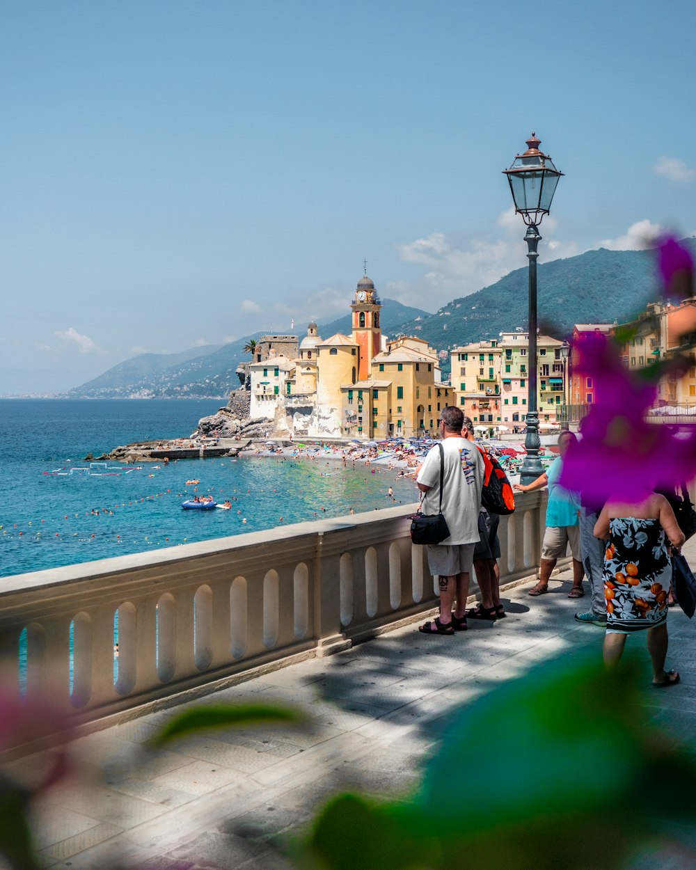 people walking on sidewalk near body of water during daytime