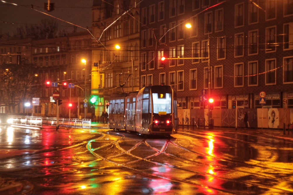 red and white tram on road during night time