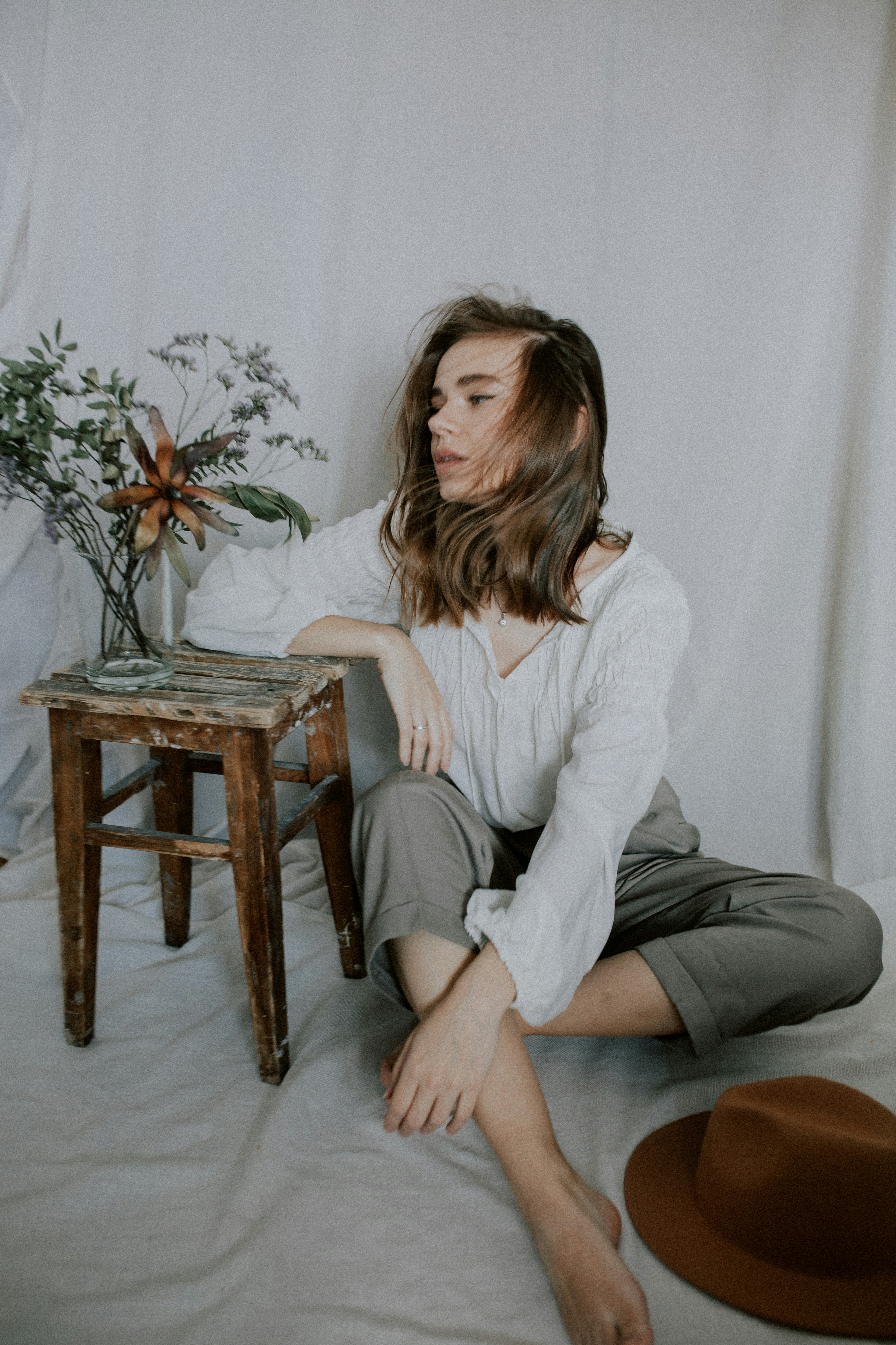 woman in white long sleeve shirt and black skirt sitting on brown wooden seat