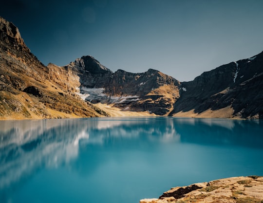 blue lake near brown mountain under blue sky during daytime in Lake O'Hara Canada