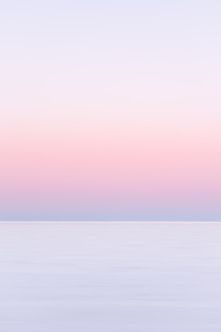 white and pink sky over the sea