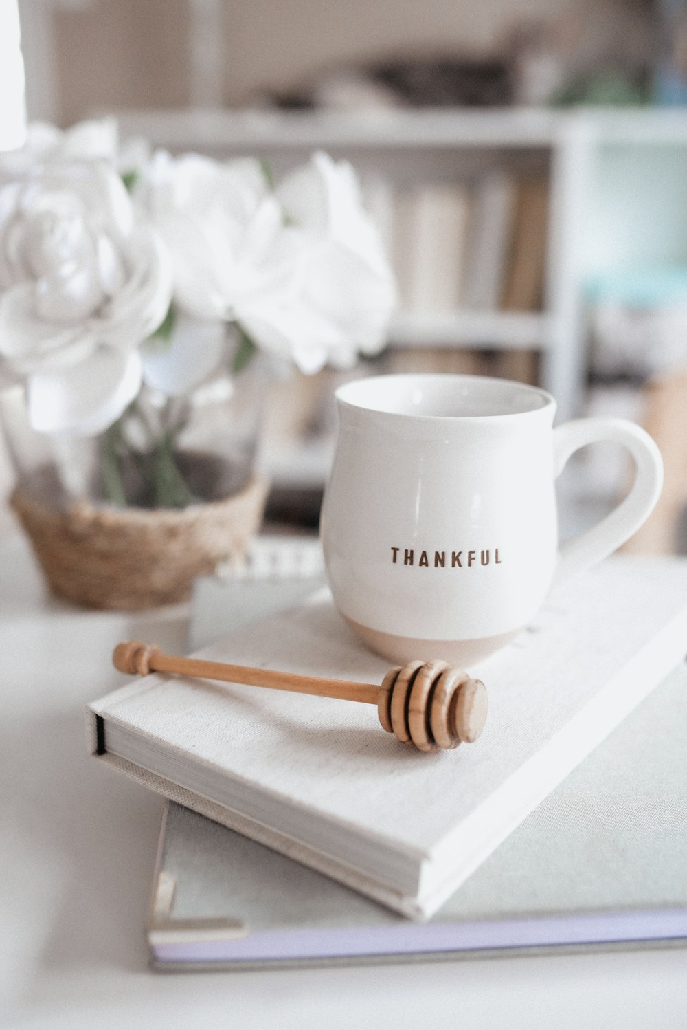 white ceramic mug beside brown wooden spoon