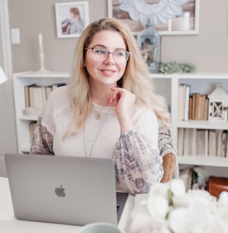 woman in white lace long sleeve shirt using silver macbook