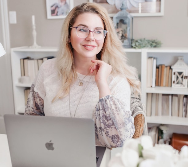 woman in white lace long sleeve shirt using silver macbook