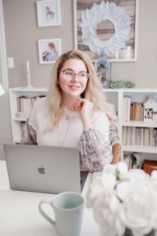 woman in white lace long sleeve shirt using silver macbook