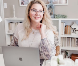woman in white lace long sleeve shirt using silver macbook