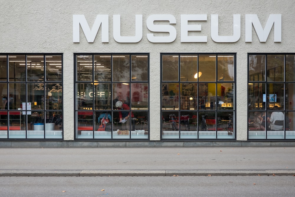 uma fachada de loja do museu com grandes janelas na lateral do edifício