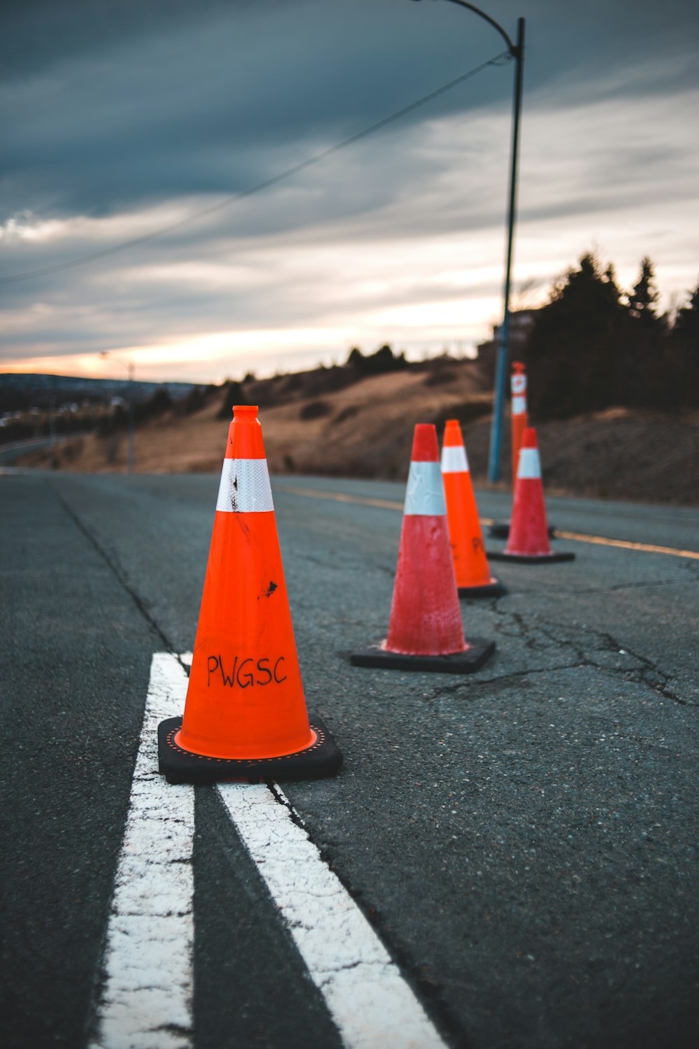 orange traffic cone on gray asphalt road during daytime