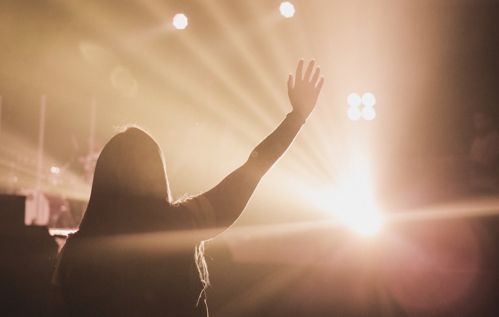 silhouette of person raising right hand