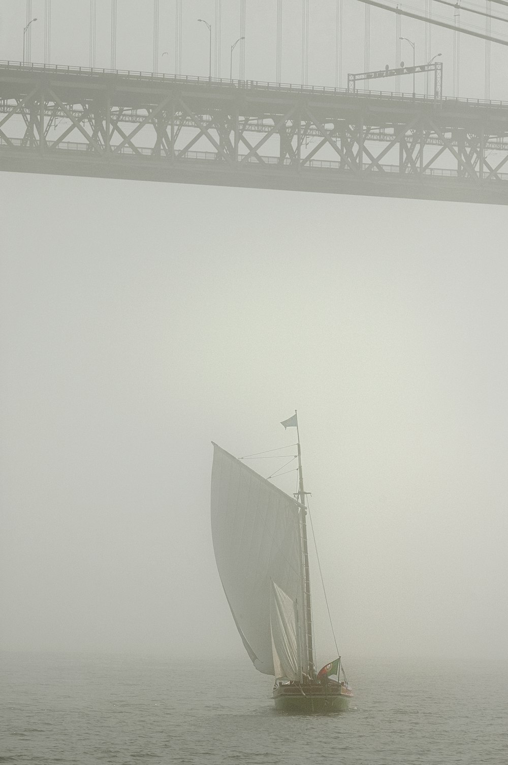 white sail boat on sea during foggy weather
