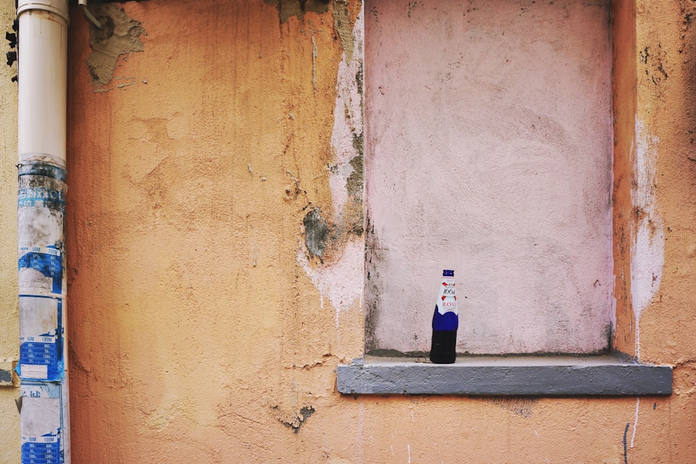 blue glass bottle on blue concrete wall