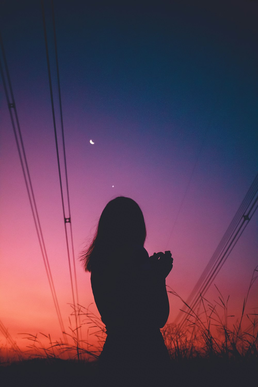 silhouette of woman holding camera during sunset