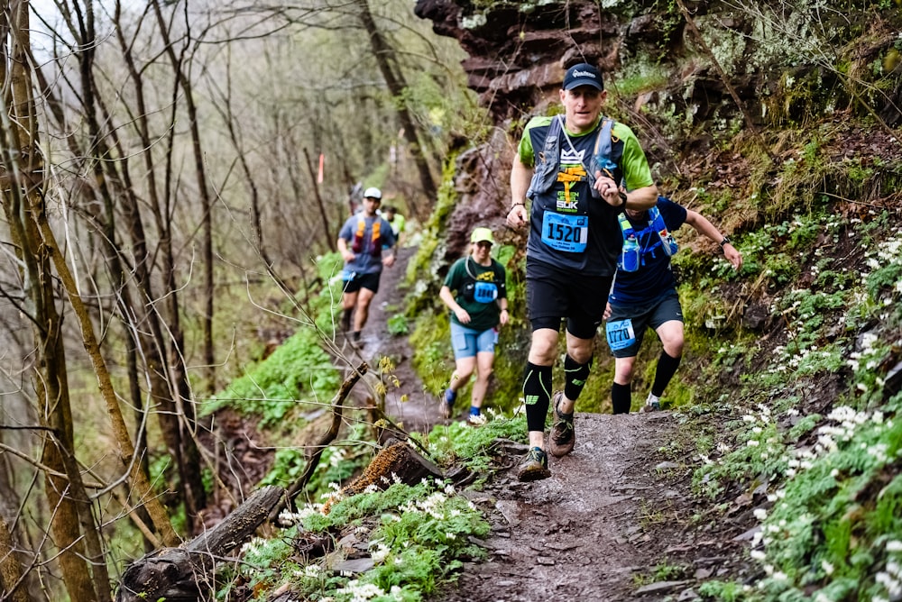 2 hombres corriendo en el bosque durante el día