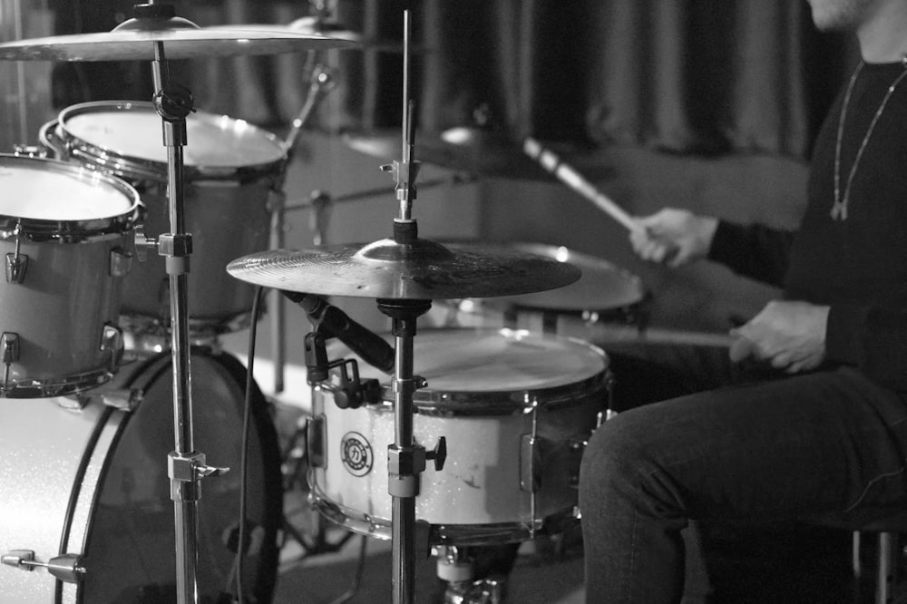 grayscale photo of man playing drum
