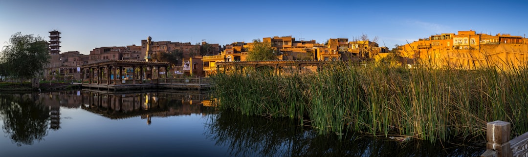 brown concrete building beside green grass and body of water during daytime