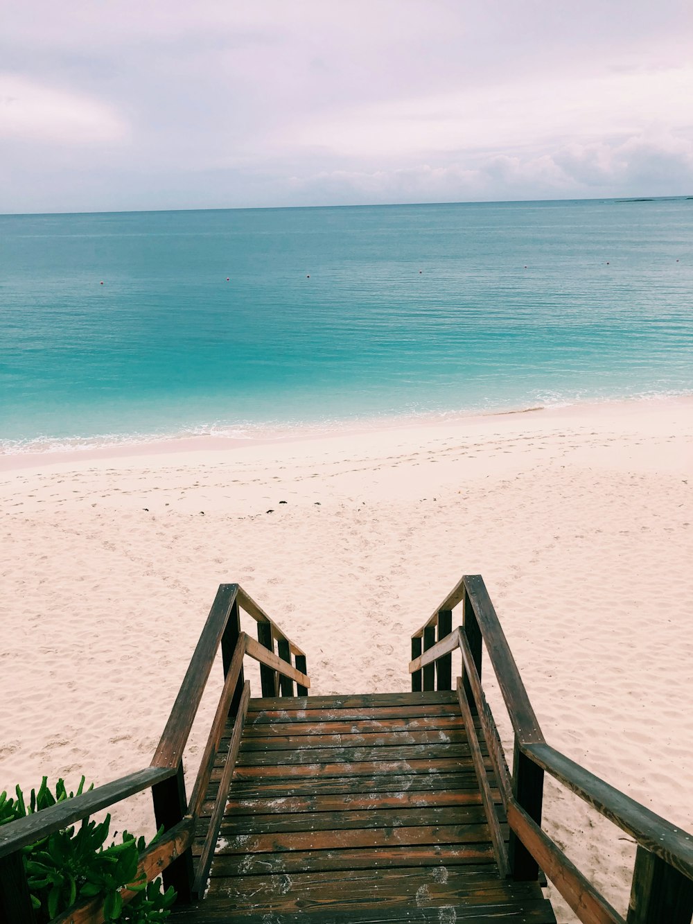 brown wooden stairs on white sand beach