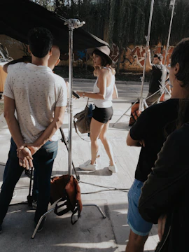 Behind-the-scenes shot of a director guiding actors on an outdoor location.