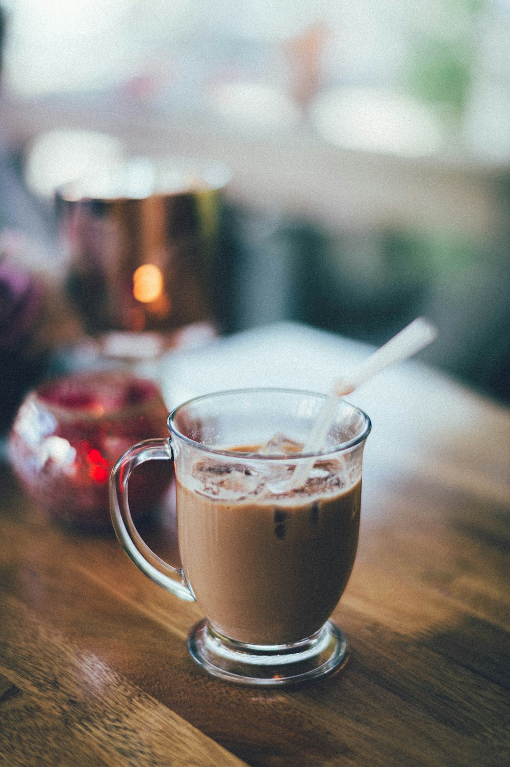 clear glass mug with brown liquid and white straw