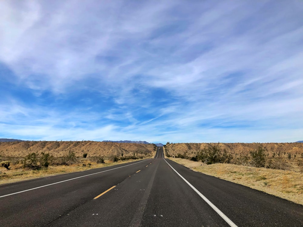 gray asphalt road under blue sky during daytime