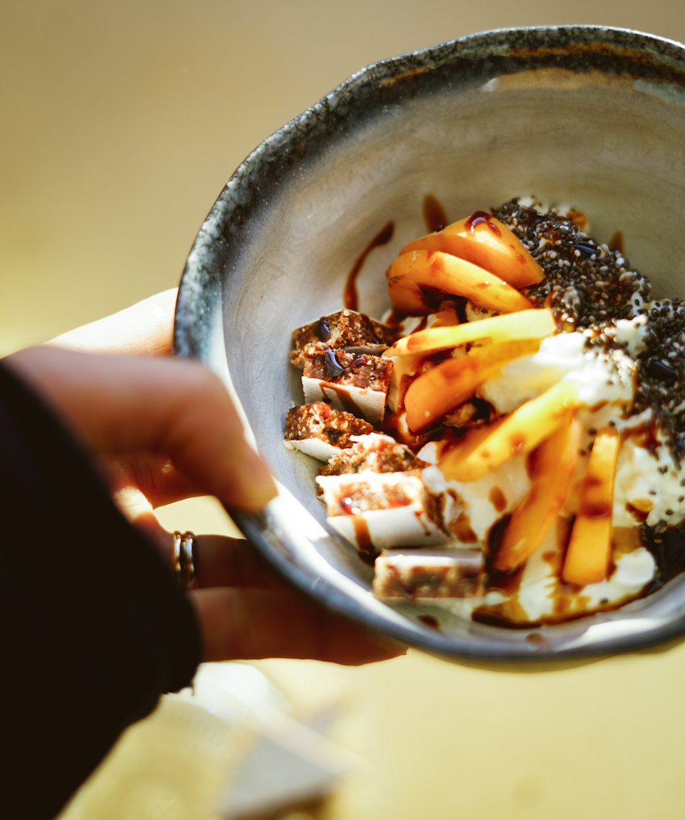 person holding stainless steel bowl with food