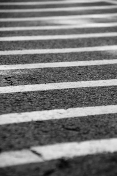 Close-up of freshly painted pedestrian crosswalk on asphalt street during daytime.