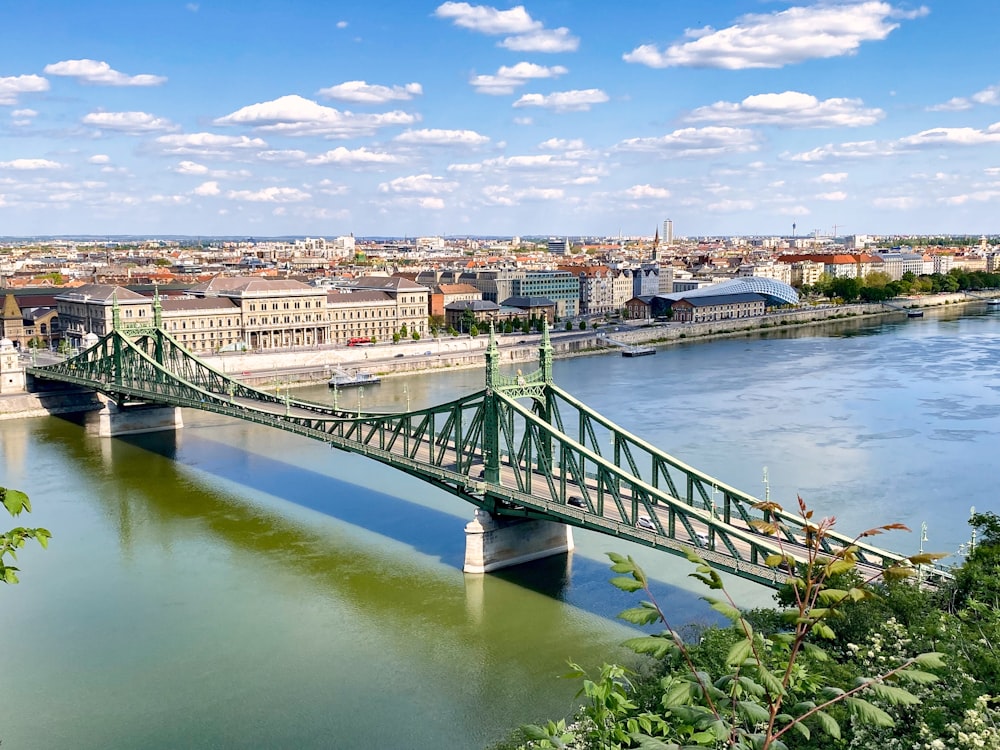 gray concrete bridge over river under blue sky during daytime