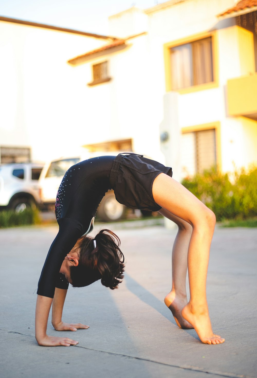 Frau in schwarzem Tanktop und schwarzer Leggings beim Yoga tagsüber