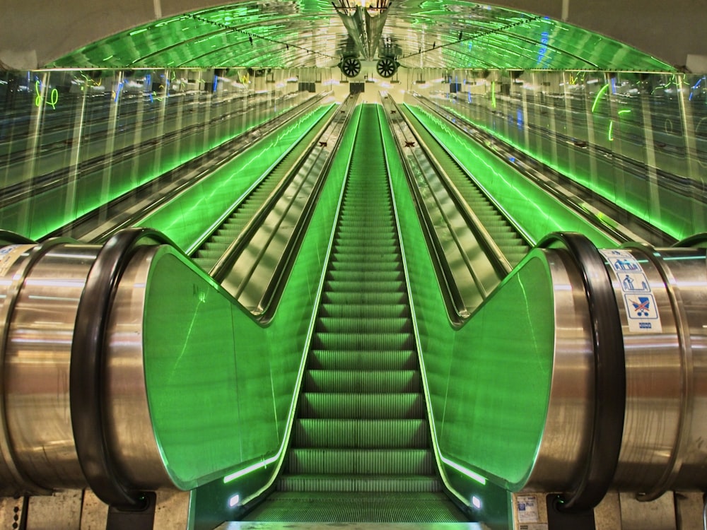 Escaleras mecánicas verdes y grises en un edificio