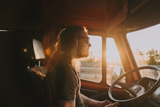 woman in gray shirt sitting on car seat during sunset