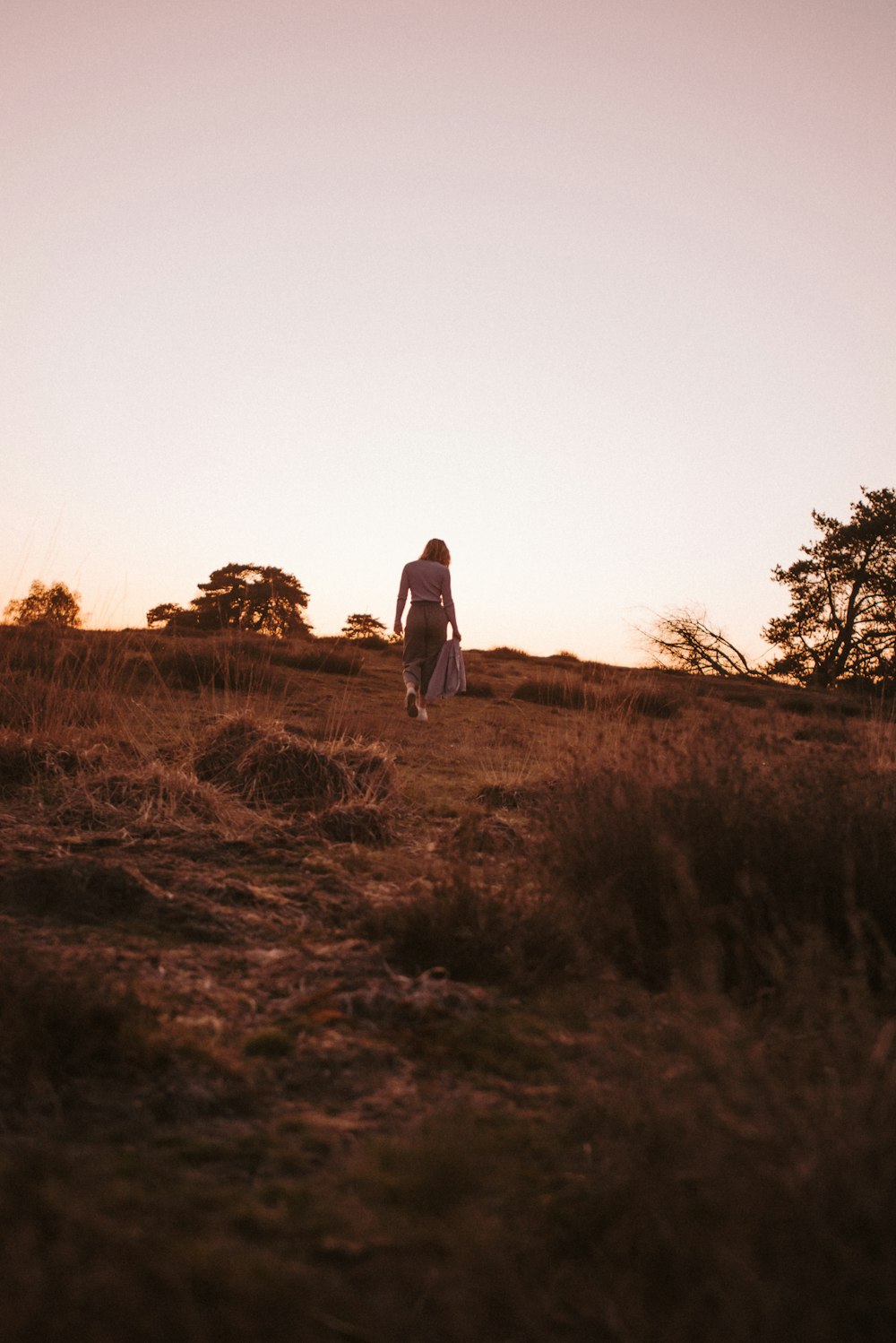 man and woman walking on brown grass field during daytime