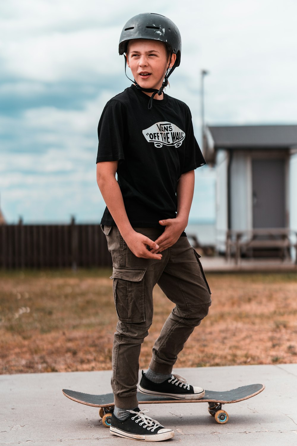 man in black crew neck t-shirt and brown denim jeans standing on brown grass field