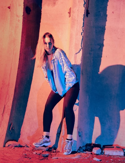 A sleek model wearing a sharp, urban-inspired jacket against a cityscape backdrop at dusk.