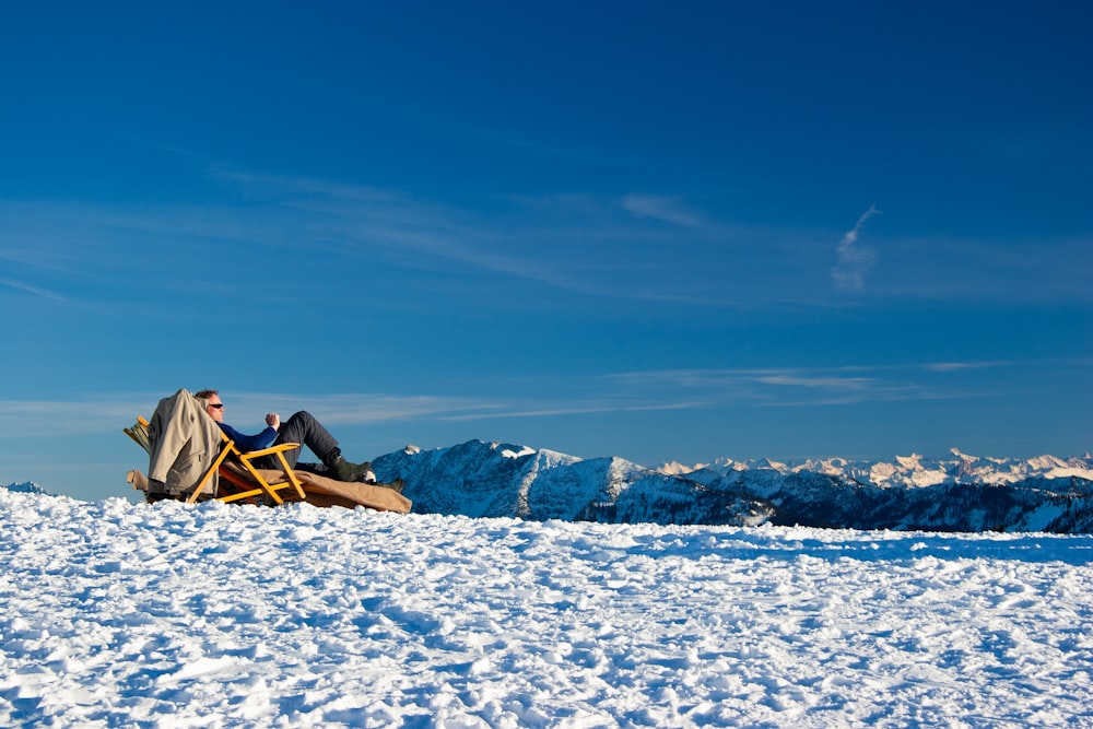 Tienda de campaña marrón en suelo cubierto de nieve bajo el cielo azul durante el día