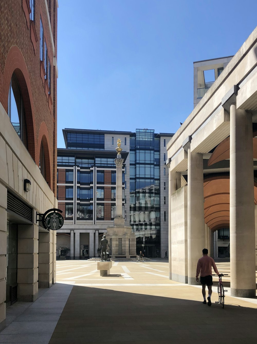 people walking on sidewalk near brown concrete building during daytime