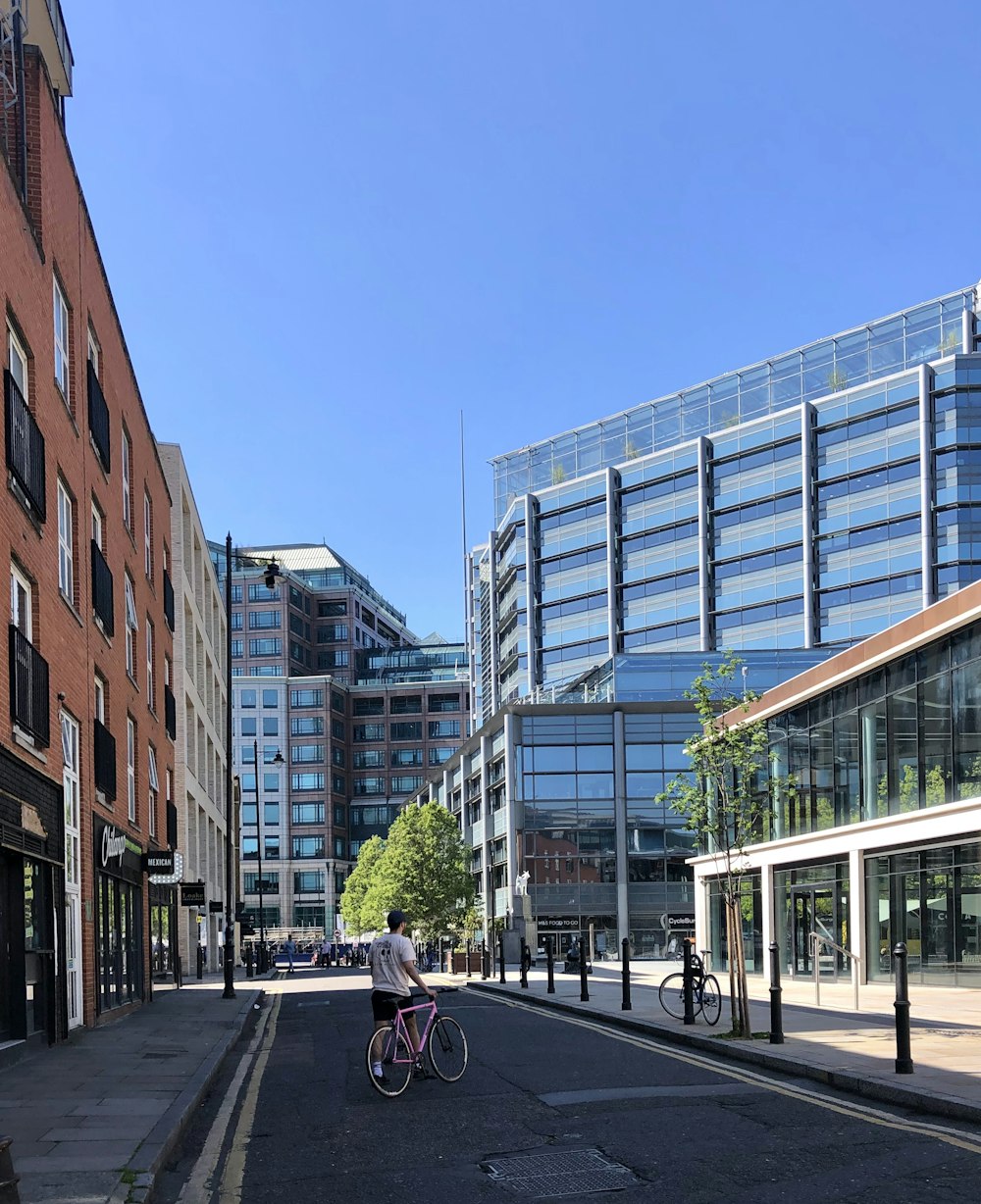 man in black jacket riding bicycle on road during daytime