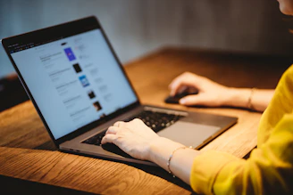 A friendly customer support agent assisting a user on a laptop with a yellow background.