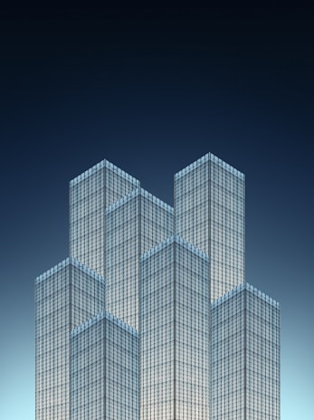A cluster of modern skyscrapers with a sleek, glass facade is set against a deep blue gradient sky. The geometric design creates an optical illusion of the towers interlocking like puzzle pieces.
