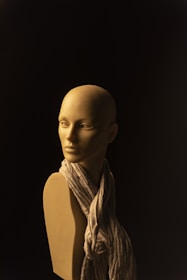 A satin bustier with a plunging neckline displayed on a mannequin against a soft, warm background.