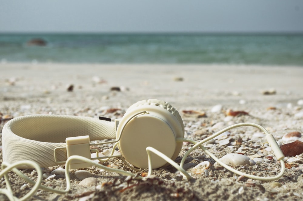 Vaso de plástico blanco en la playa de arena blanca durante el día