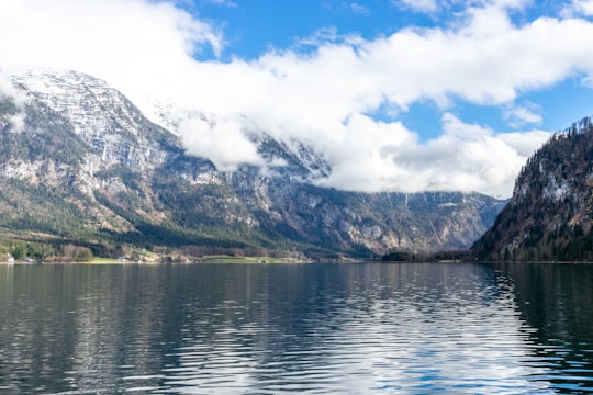 body of water near mountain under white clouds during daytime in Bad Goisern Austria