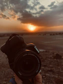 UBM Canon camera in action, held by a photographer capturing a sunset.