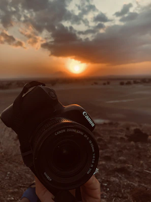 UBM Canon camera in action, held by a photographer capturing a sunset.