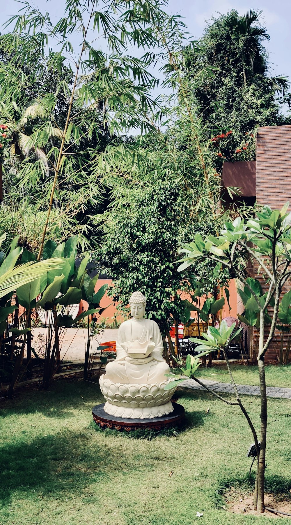 white ceramic statue near green tree during daytime